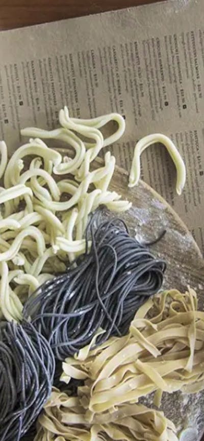 Some fresh pasta next to a menu on a table