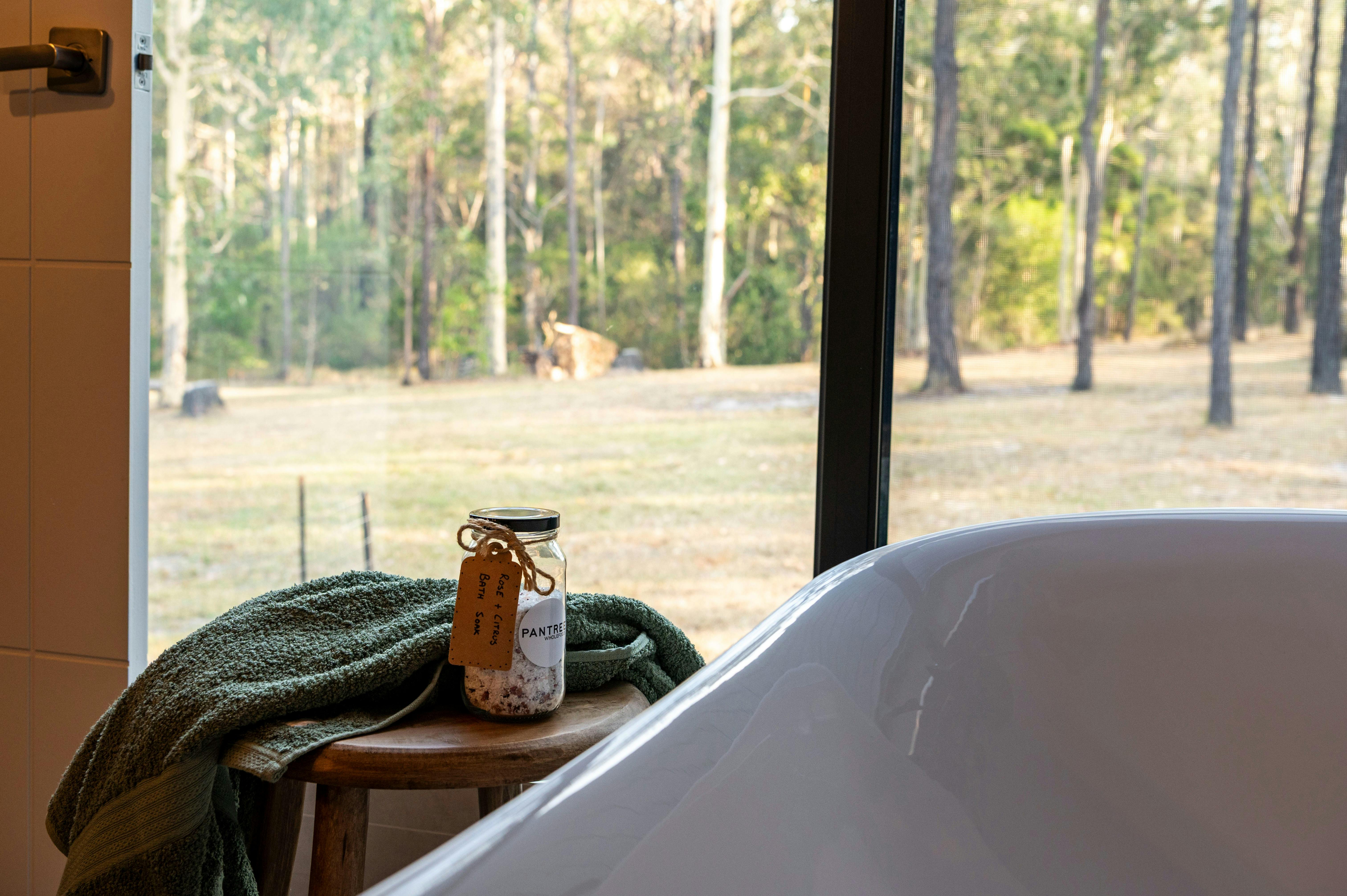 Freestanding bath with bush outlook at Mawarra Retreat with bath salts and towel