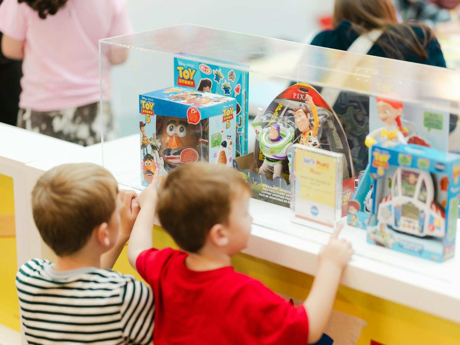 Children looking at Toy Story toys in the Visual Merchandise cabinets