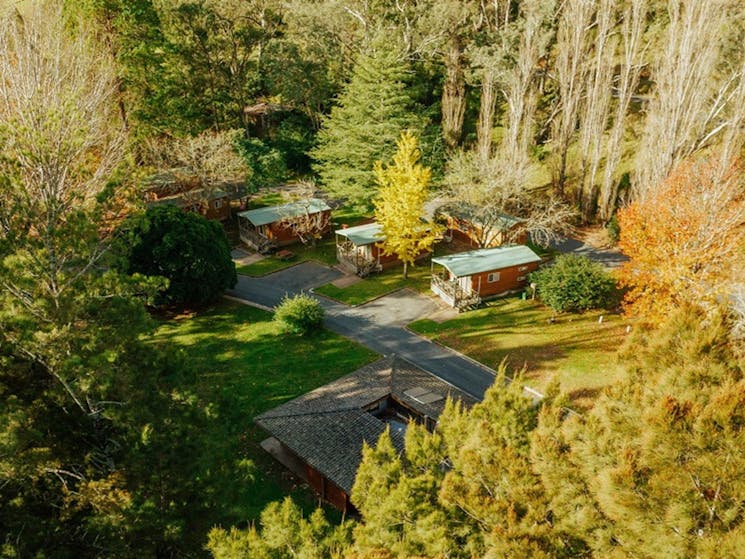 Aerial view of Wombeyan Caves cabins, which are set in a clearing surrounded by tall trees. Credit: