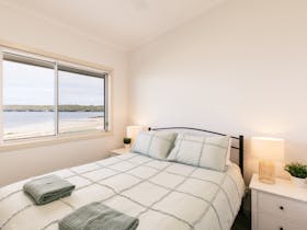 One of two queen bedrooms at Beachside, you can watch the dolphins, seals and wildlife passing by