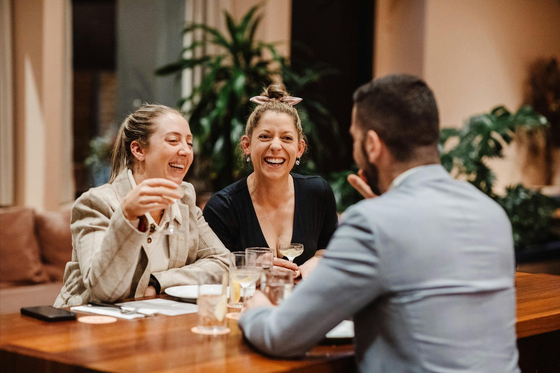 Friends sharing cocktails and laughter at Never Never Distillery Door, McLaren Vale