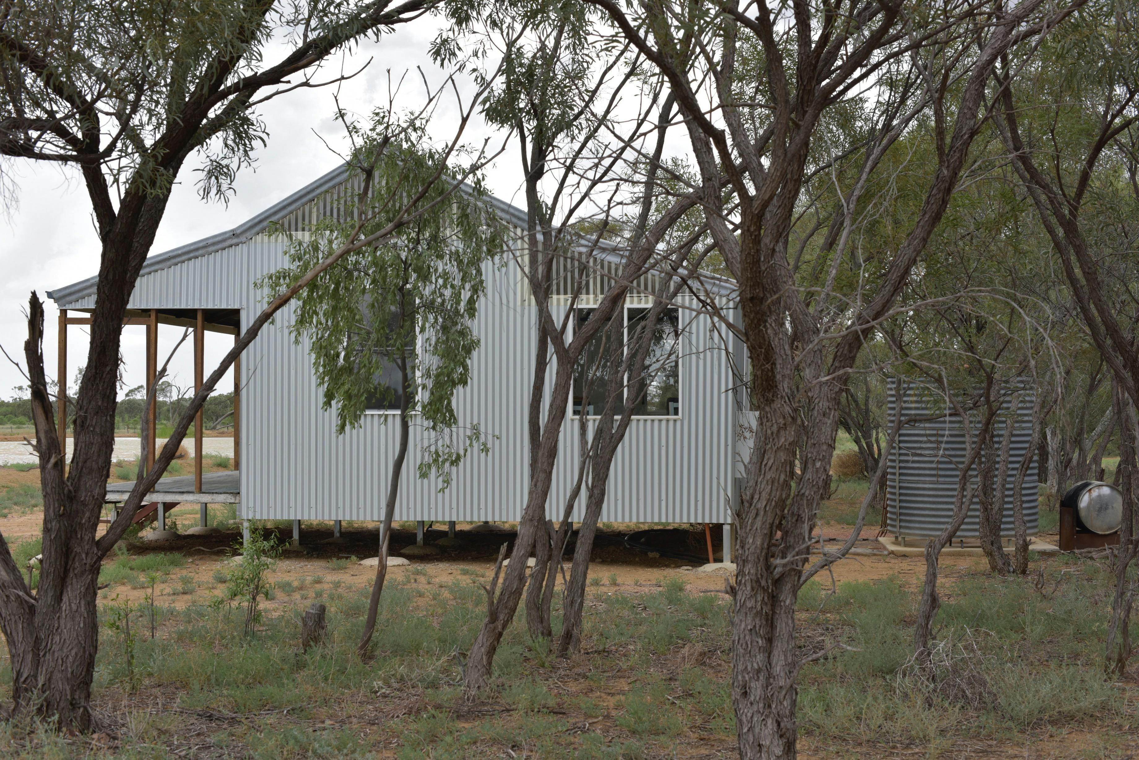 a view of a cottage from behind the trees