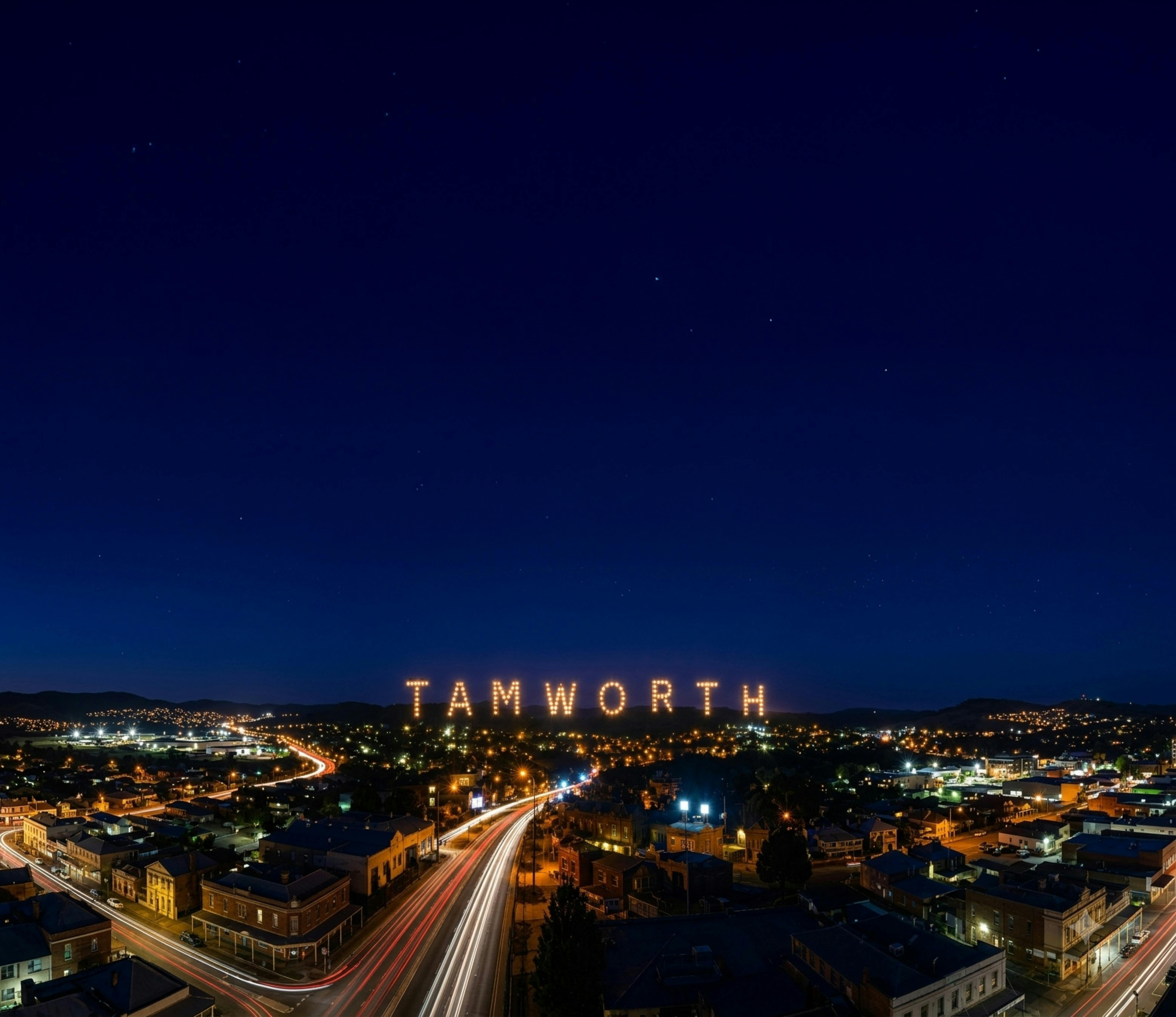 Tamworth city skyline at night with the word "TAMWORTH" lit up in lights in the distance