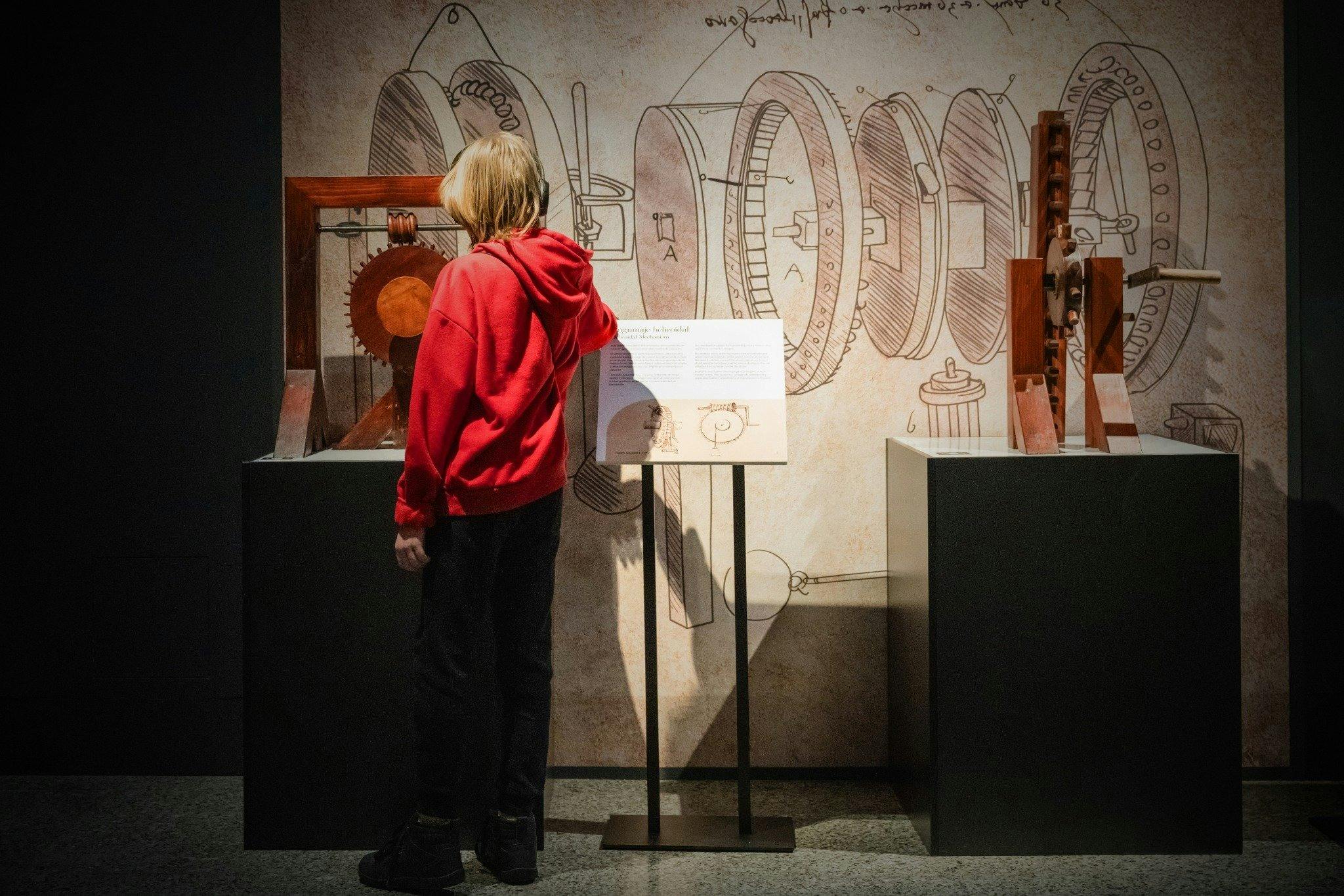 Visitor explores Leonardo da Vinci–inspired machines and sketches in an immersive exhibition.