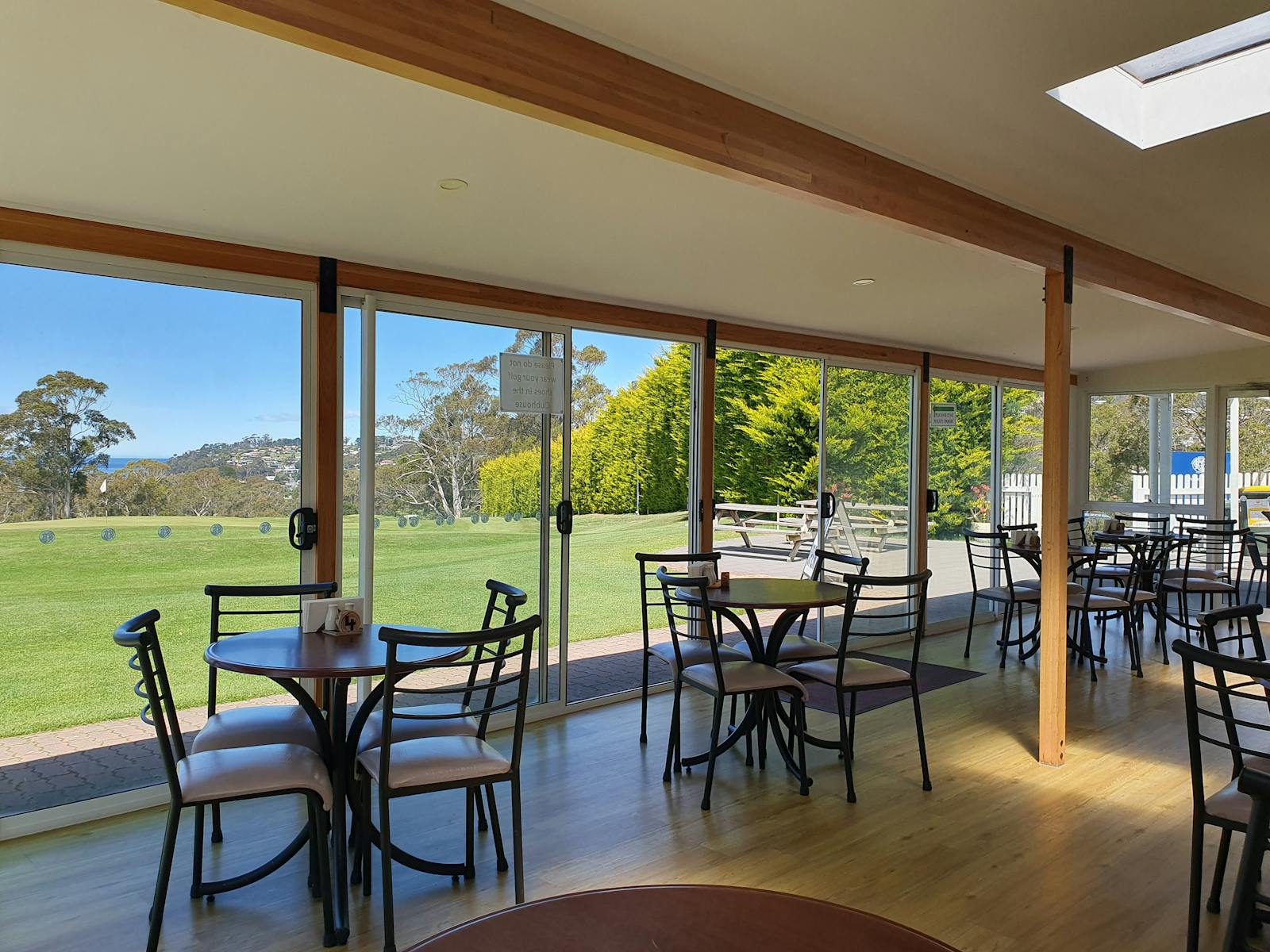 Indoor bar seating with view out to the 18th green at Kingston Beach Golf Club