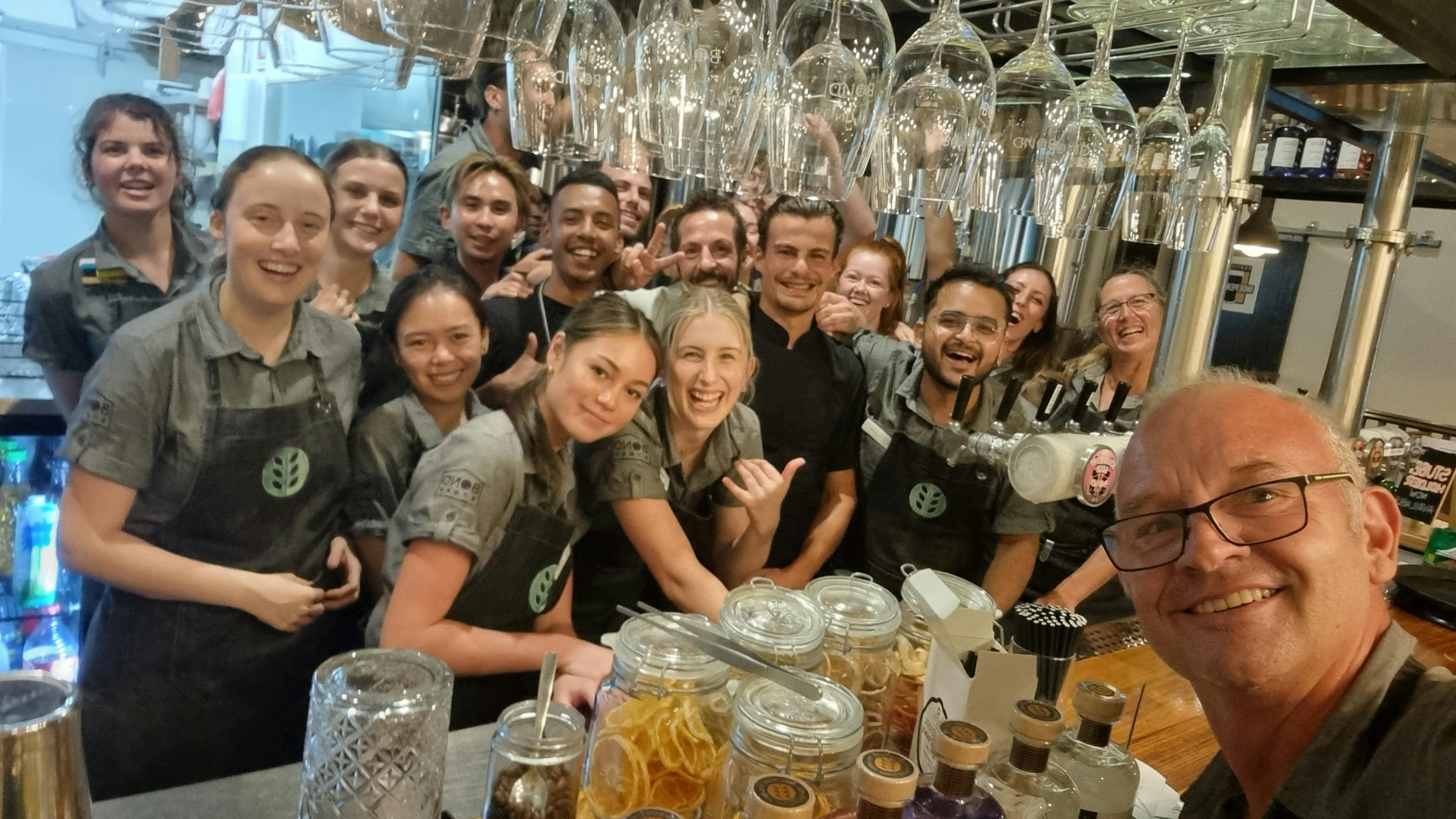 BStaff standing behind the bar very happy.