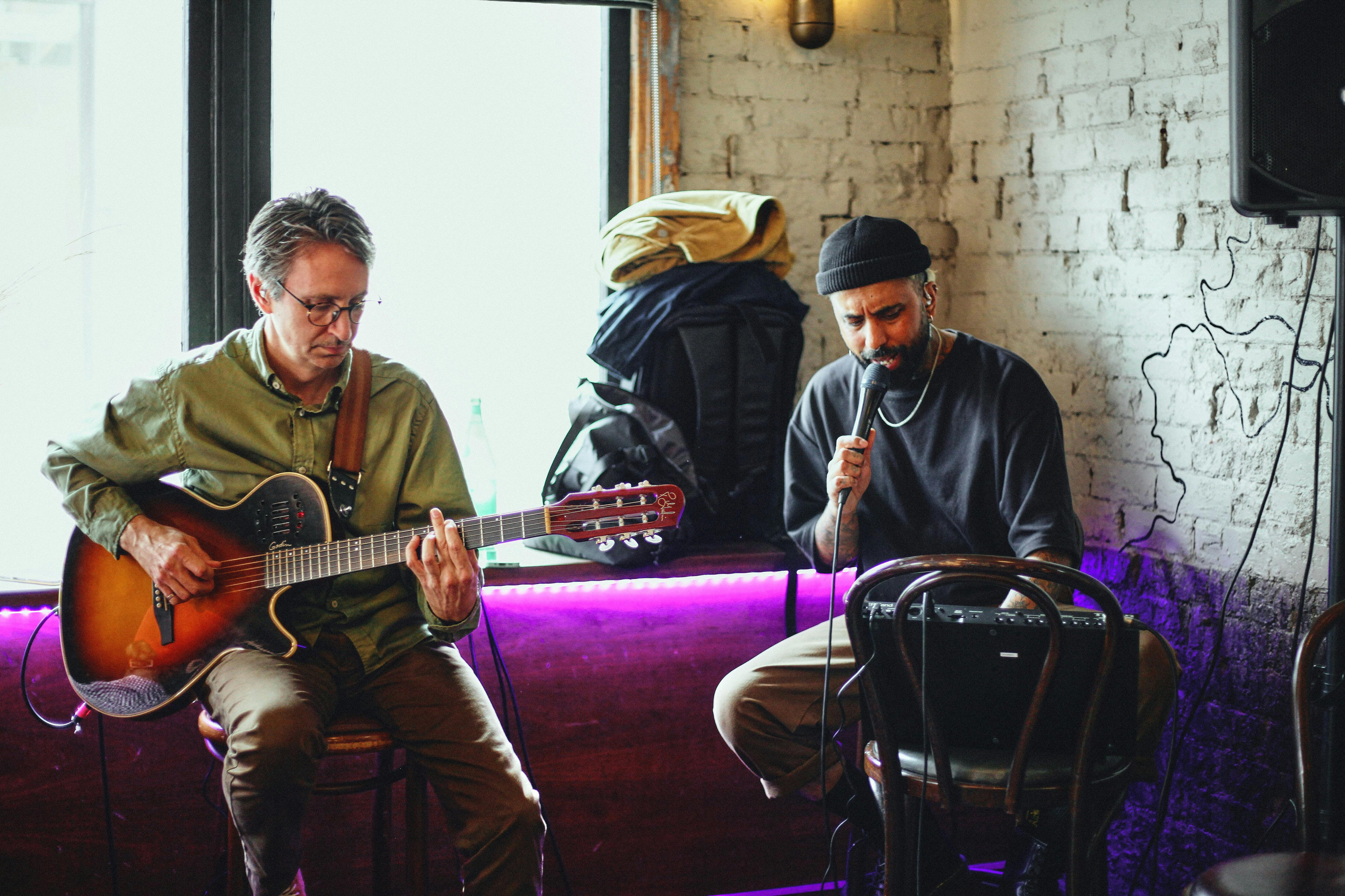 기타와 마이크가 있는 두 명의 라이브 음악 아티스트