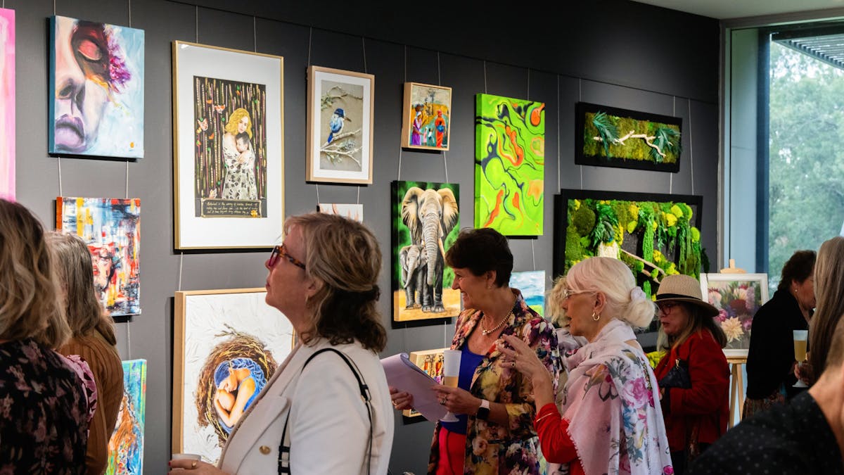 People viewing hung artworks in a gallery