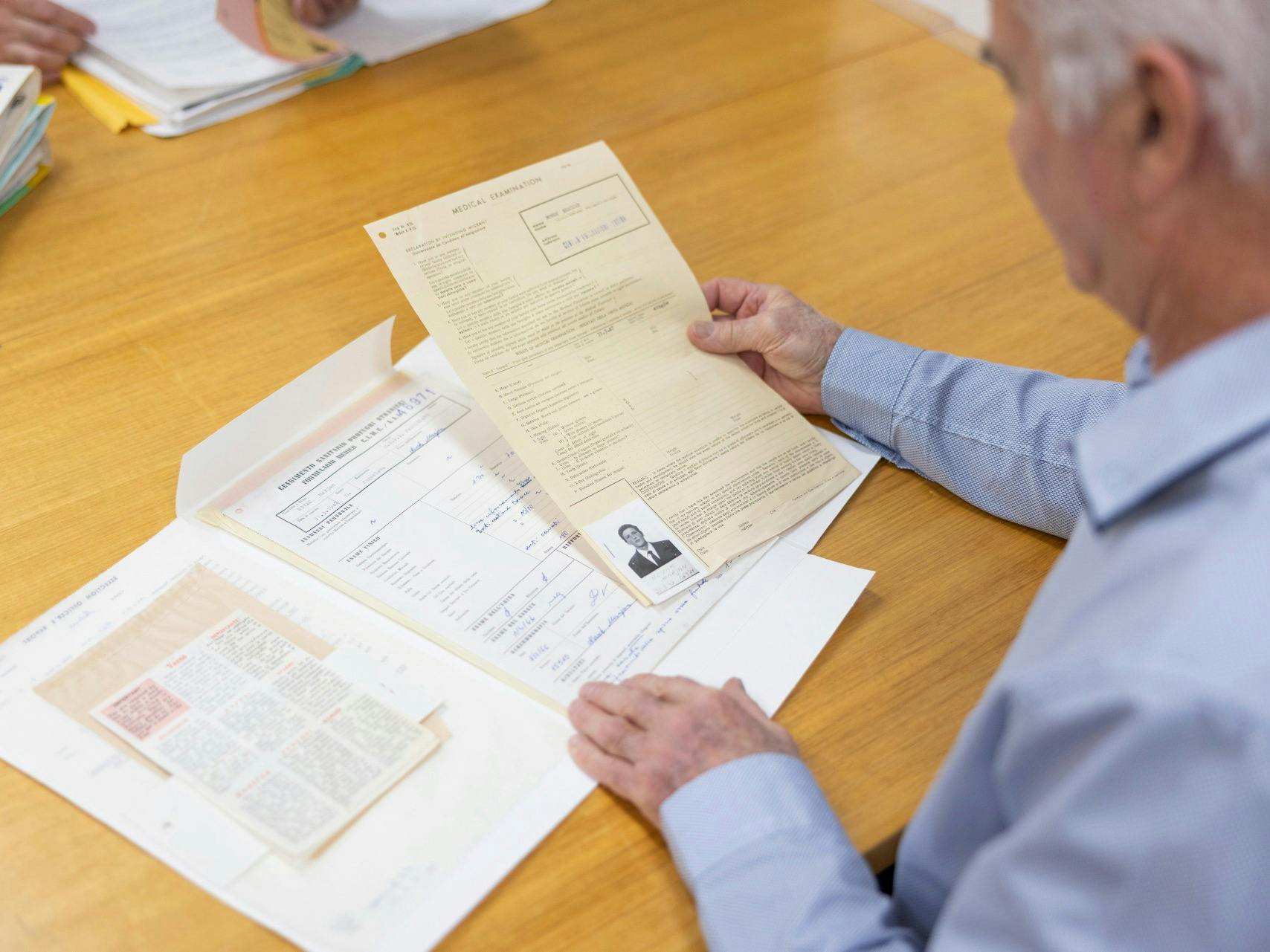 Photpgraph of a visitor reading archival records at a table