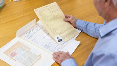 Photpgraph of a visitor reading archival records at a table
