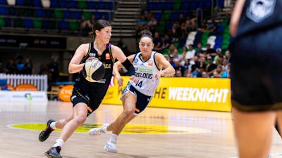 UC Capitals player driving to the basket for a layup during a WNBL game.
