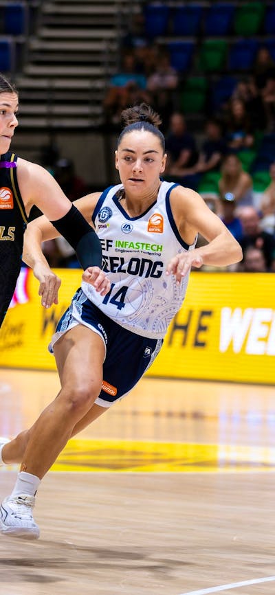 UC Capitals player driving to the basket for a layup during a WNBL game.