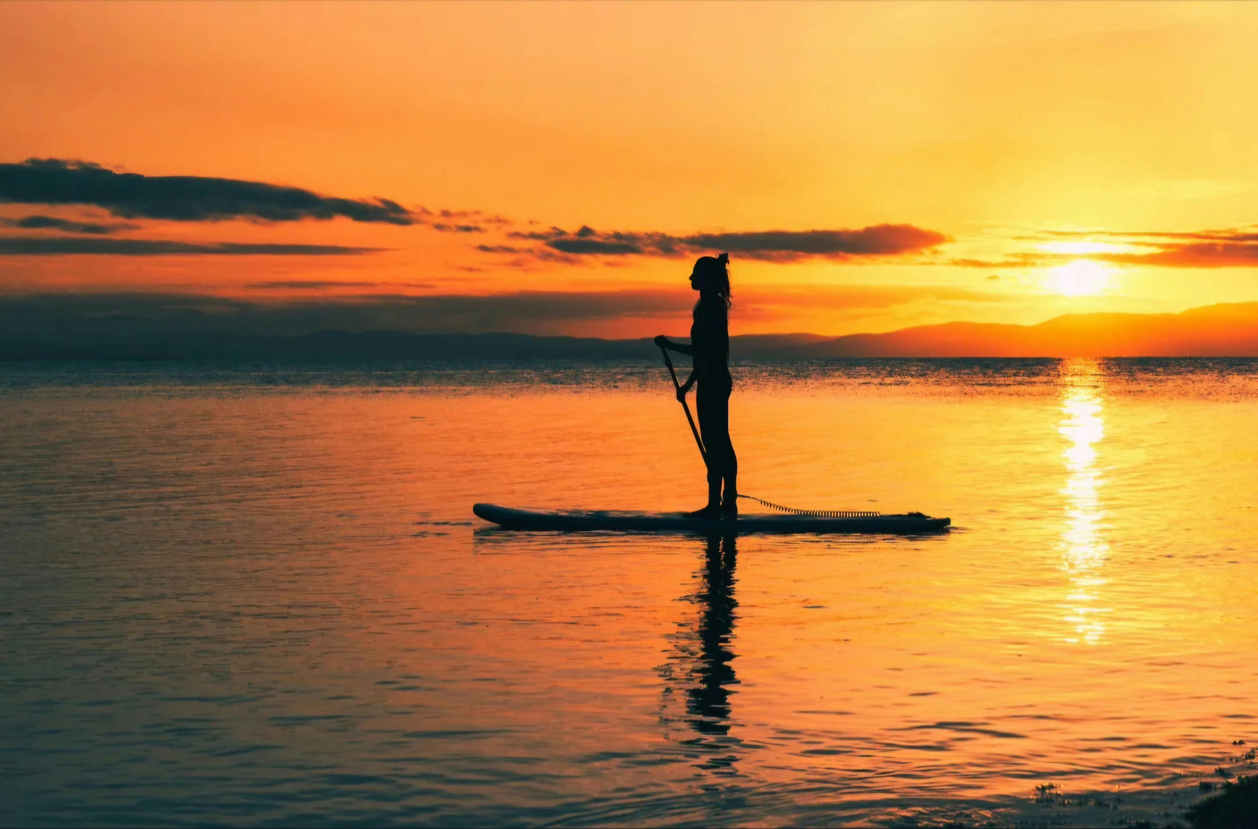 Persom paddleboarding on glassy, calm conditions in  Coles Bay in Tasmani.