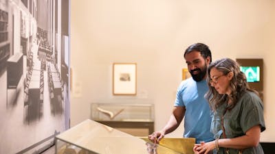 A man and woman viewing a collection in a gallery