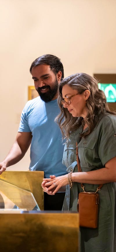 A man and woman viewing a collection in a gallery