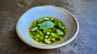 Broad beans, peas + nasturtium in a clear broth.