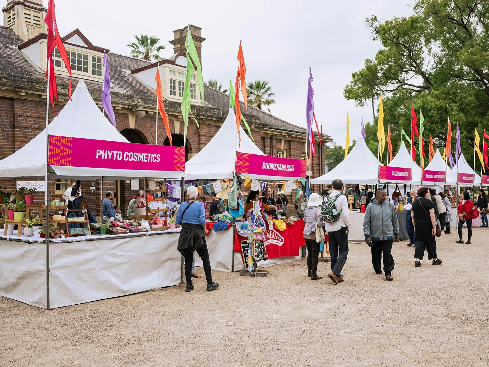 Outdoor Foundation Day market scene featuring white tents with colorful banners