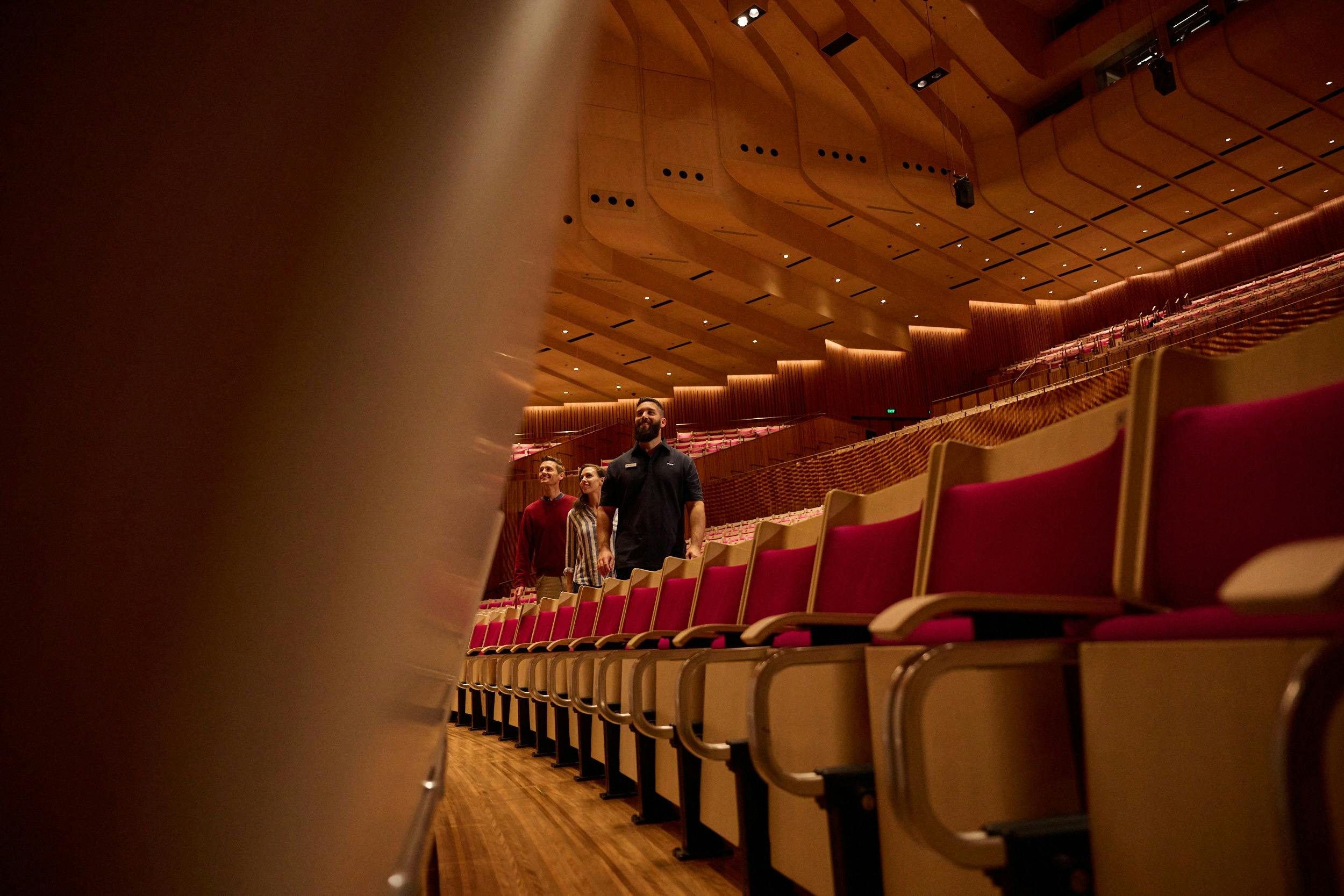 콘서트 홀의 매점 사이로 남자와 여자를 안내하는 투어 가이드