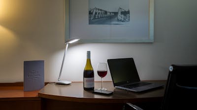 Large working style desk with a bottle of local wine from Lerida estate