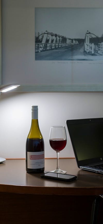 Large working style desk with a bottle of local wine from Lerida estate