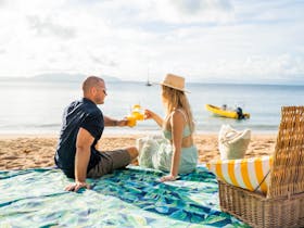 Couple on picnic rug on a beach