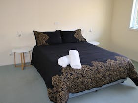 Queen bed in a room with towels on the bed