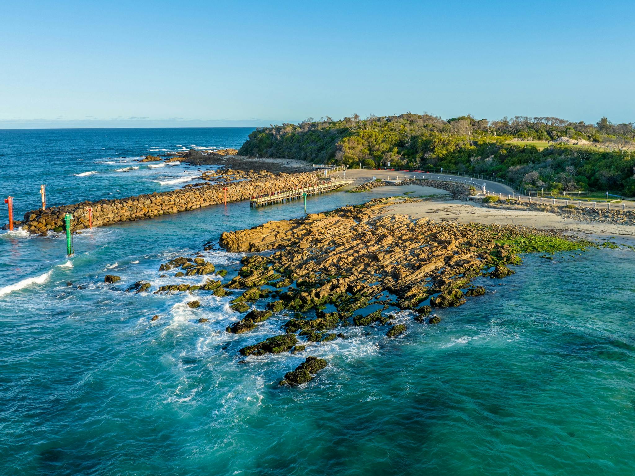 Rock wall running alongside boat ramp at Bastion Point, waves crashing on the rocks
