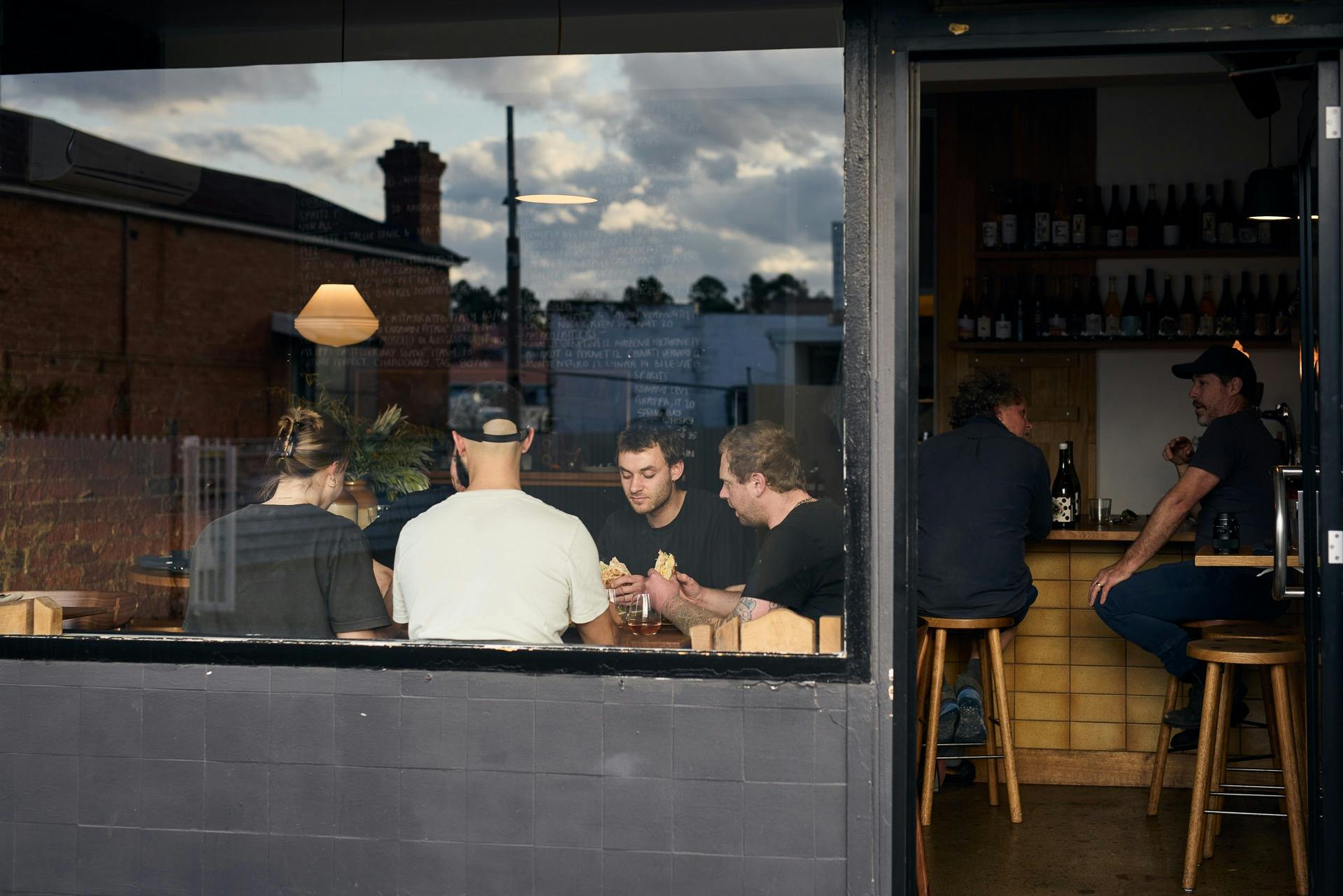 Image shows a 20 seat venue shot from outside with a view of diners through a large glass window