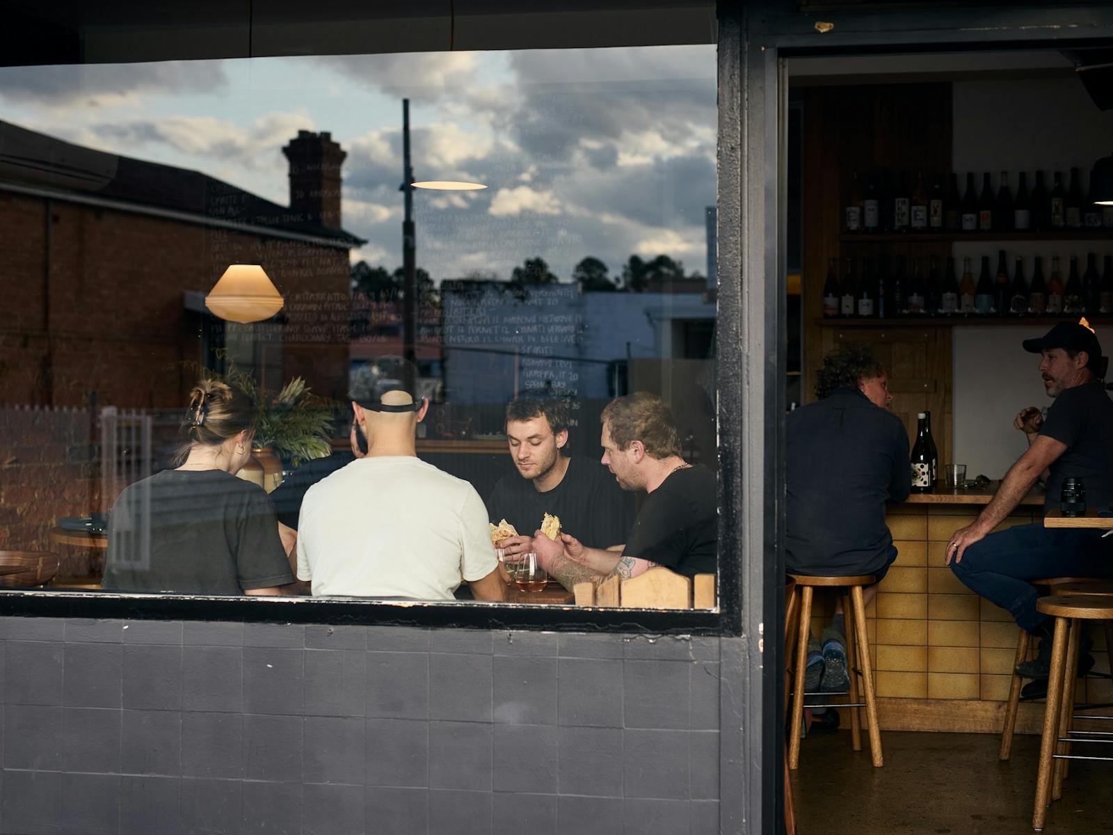 Image shows a 20 seat venue shot from outside with a view of diners through a large glass window