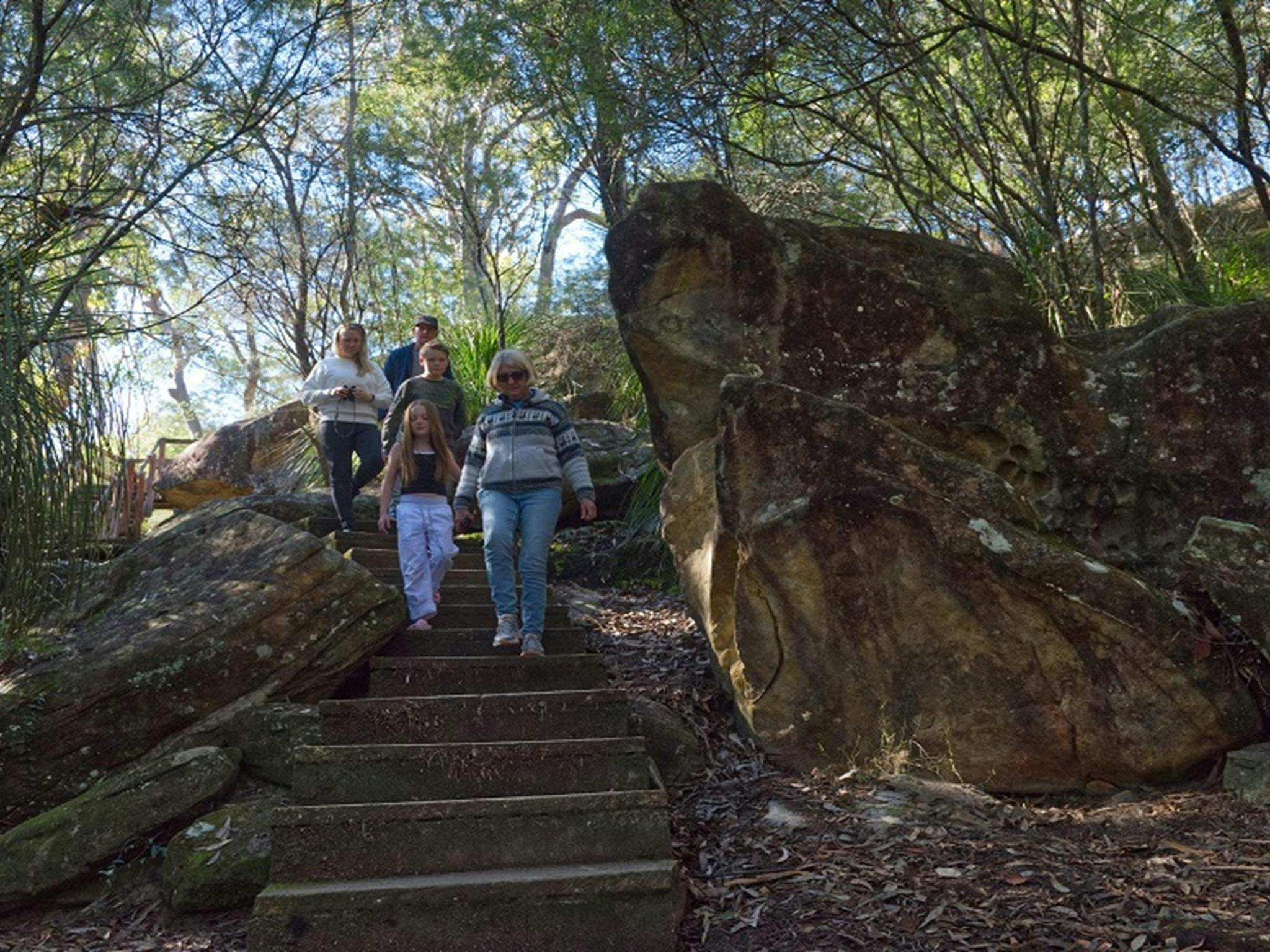 Eine Familie machte sich auf den Weg die Stufen des Wanderwegs Somersby Falls im Brisbane Water National Park hinunter.
