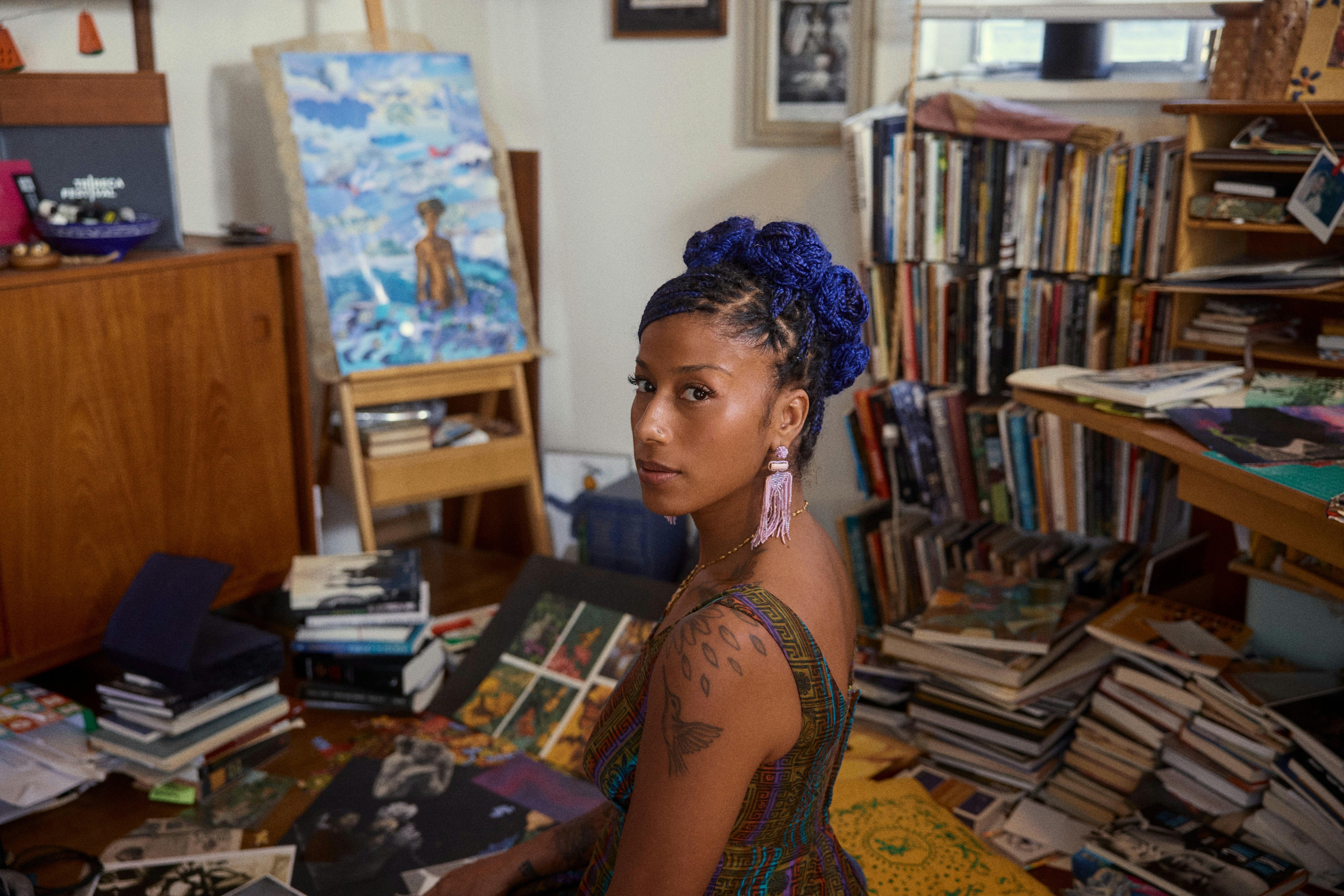 Portrait image of a woman sitting in a room full of records and books.