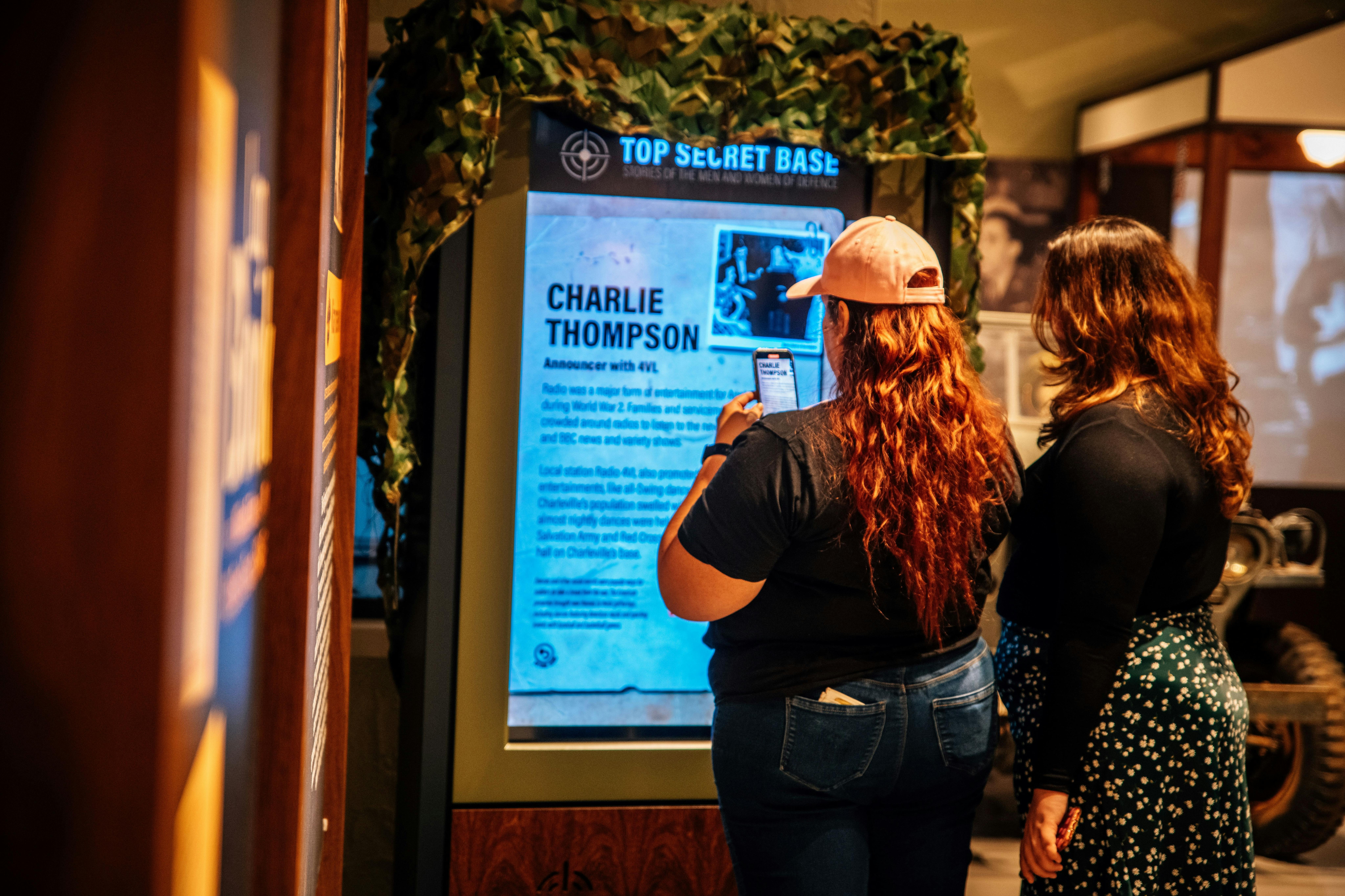 two peopke reading an interactive display showing a local serviceman story