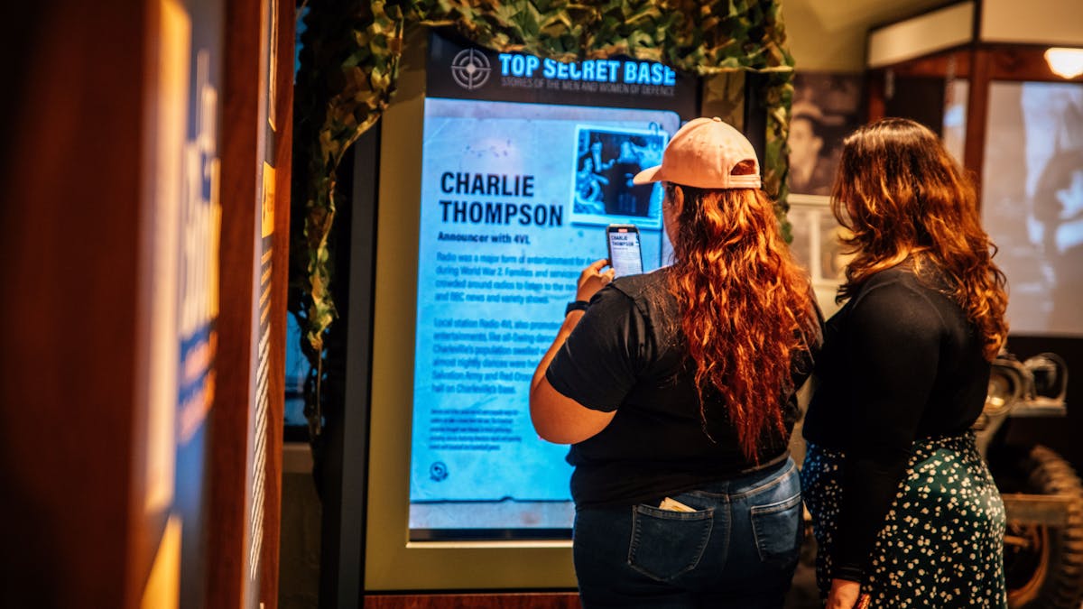 two peopke reading an interactive display showing a local serviceman story