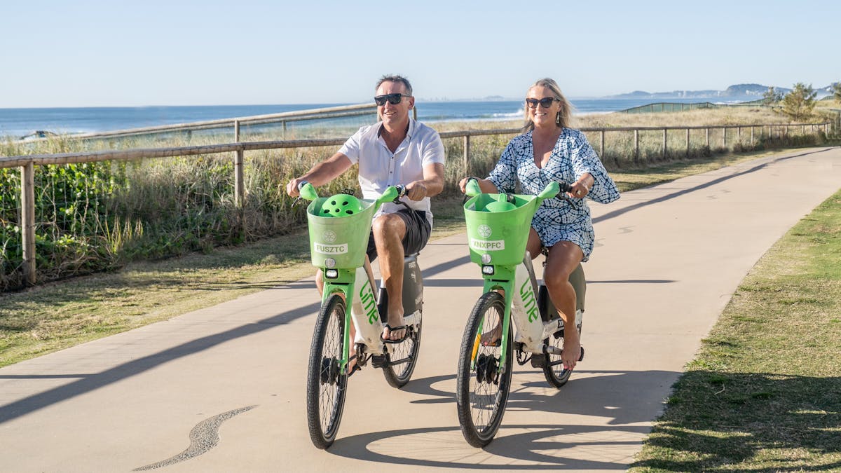 Couple riding bike along the oceanway