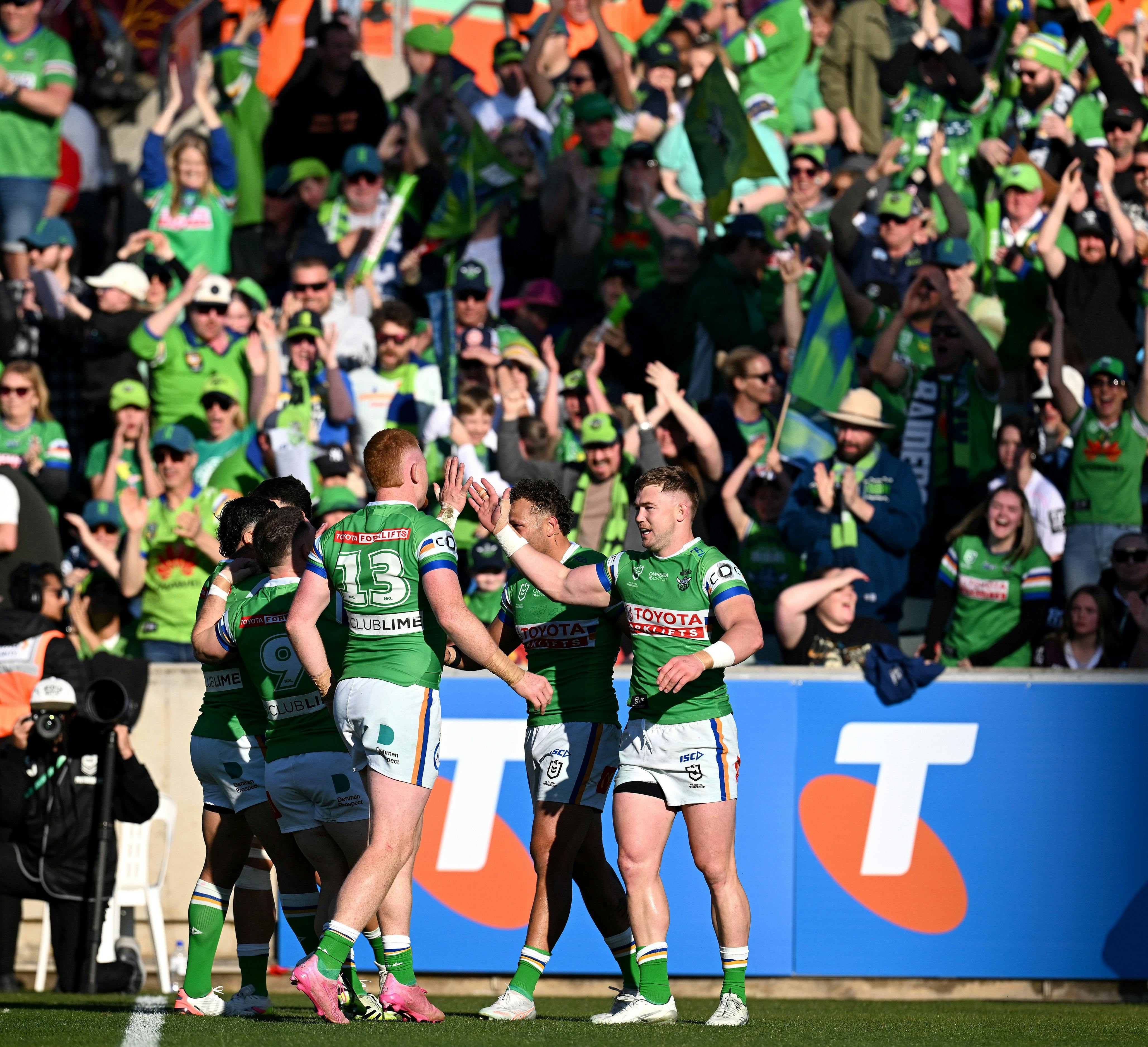 Canberra Raiders players and fans celebrate a try.
