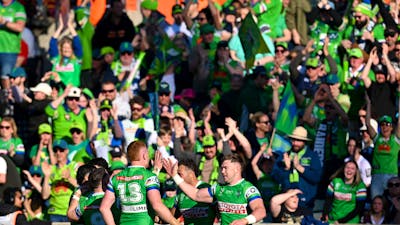 Canberra Raiders players and fans celebrate a try.
