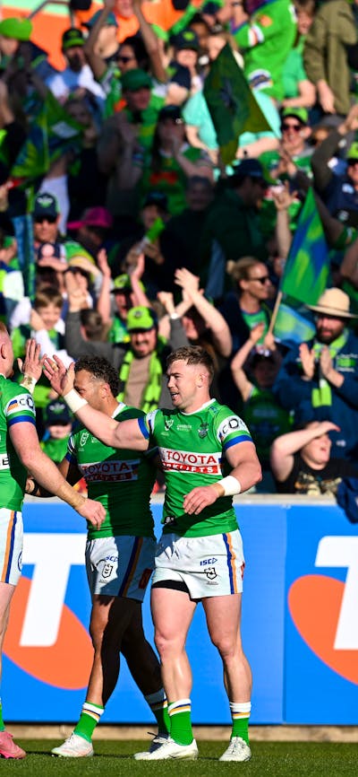 Canberra Raiders players and fans celebrate a try.