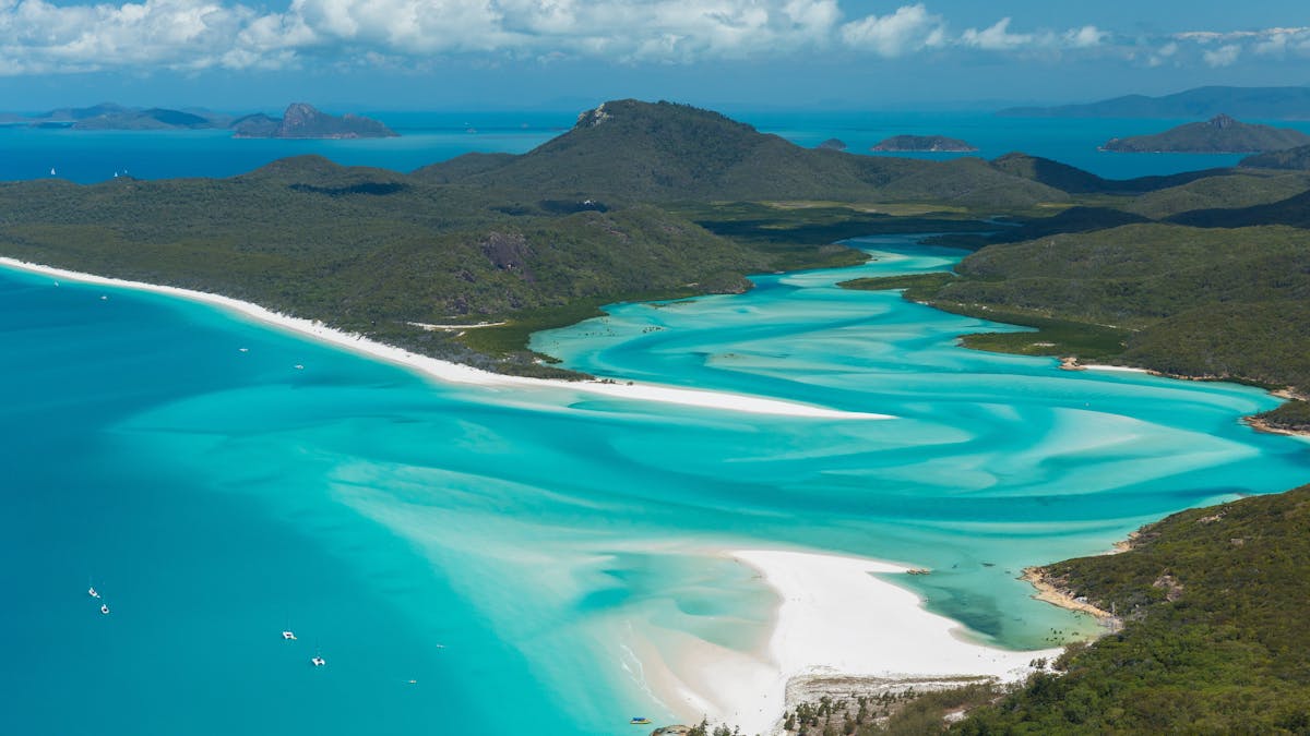 Aerial view of the swirling fusion of white sand and turquoise water into the inlet