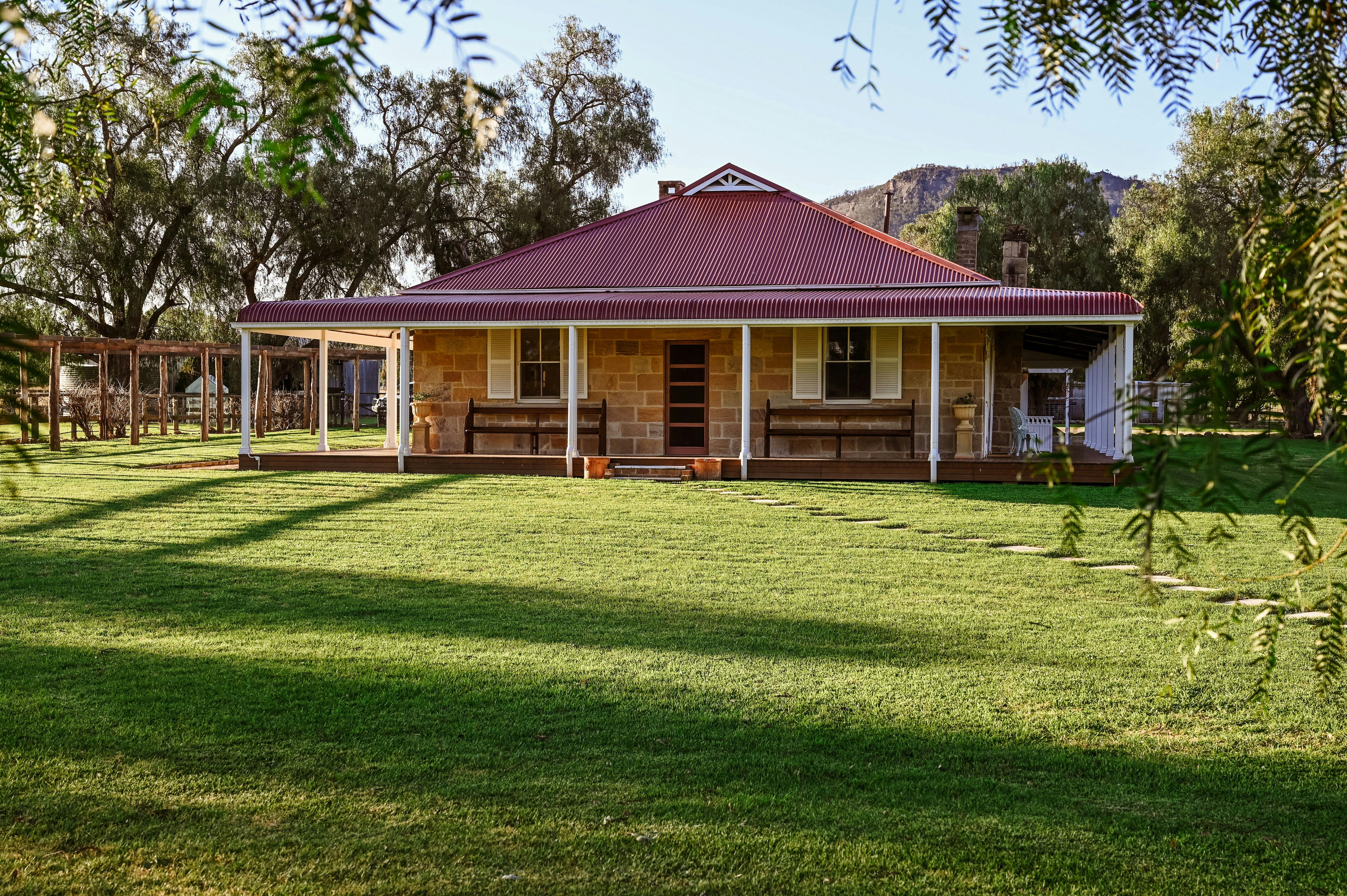 Historic Myalla sandstone homestead sheltered by an expansive bullnose wrap around verandah