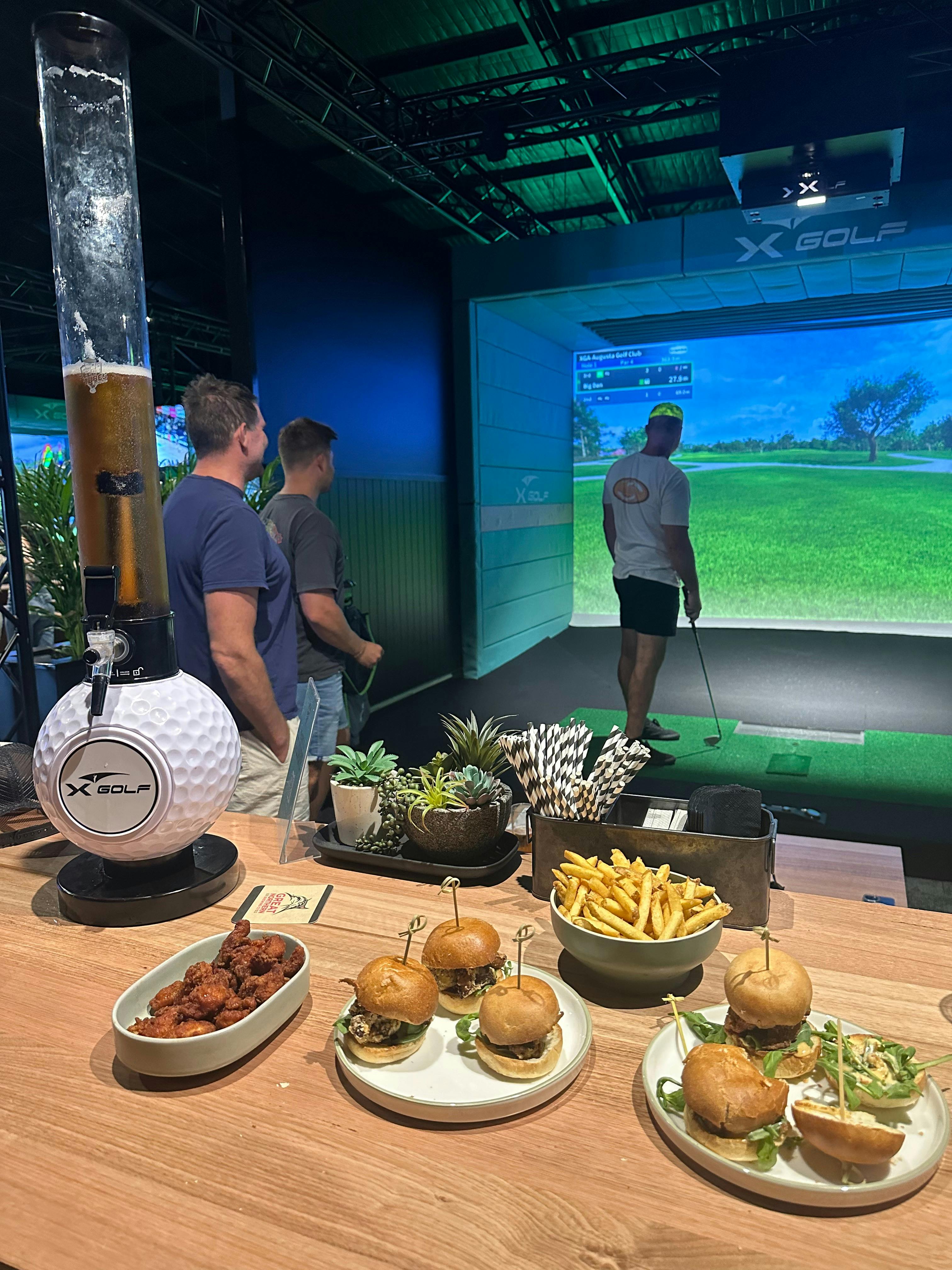 People playing indoor golf with beer and dinner