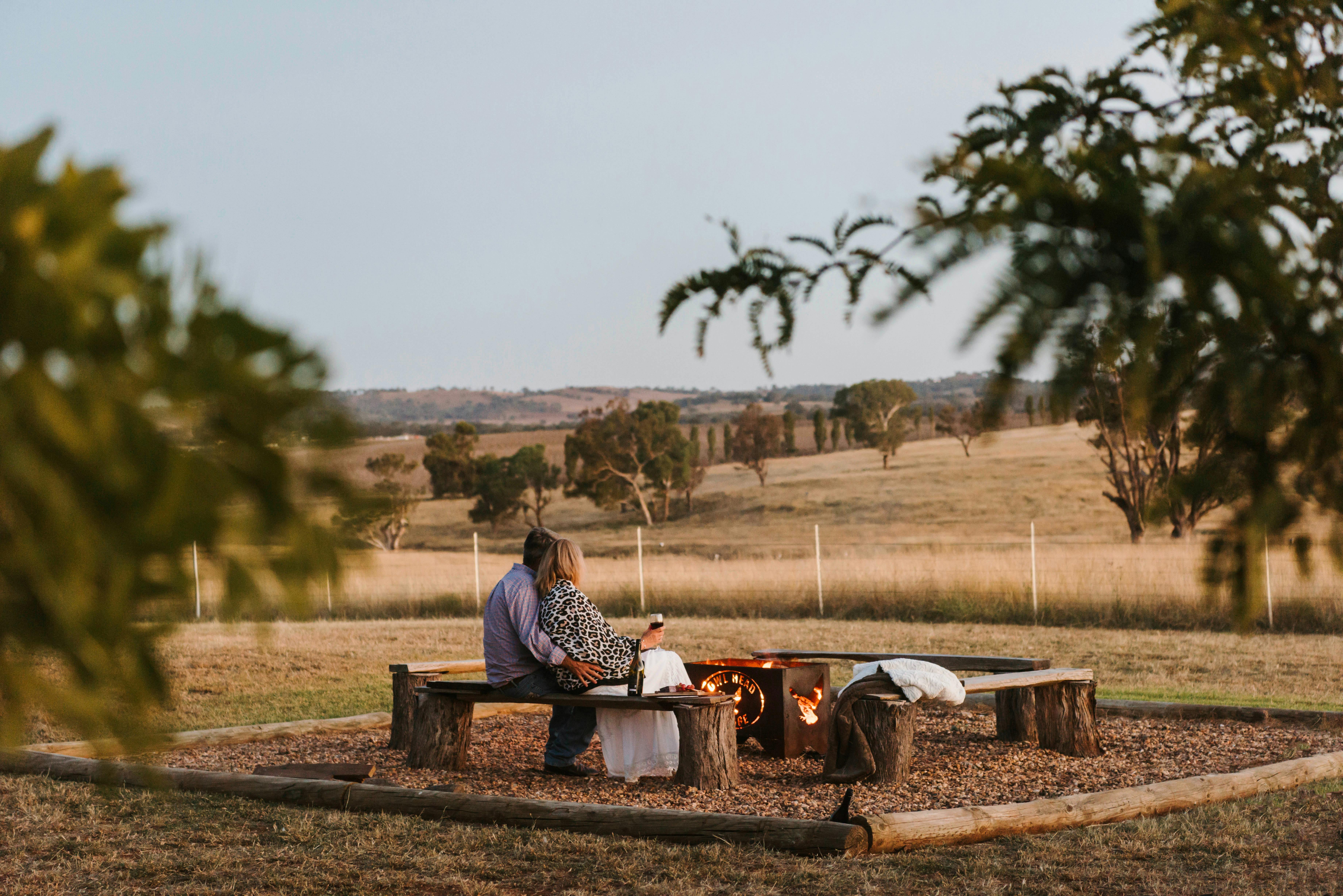 Couple enjoying the firepit and serene country views at Owl Head Lodge, Gulgong