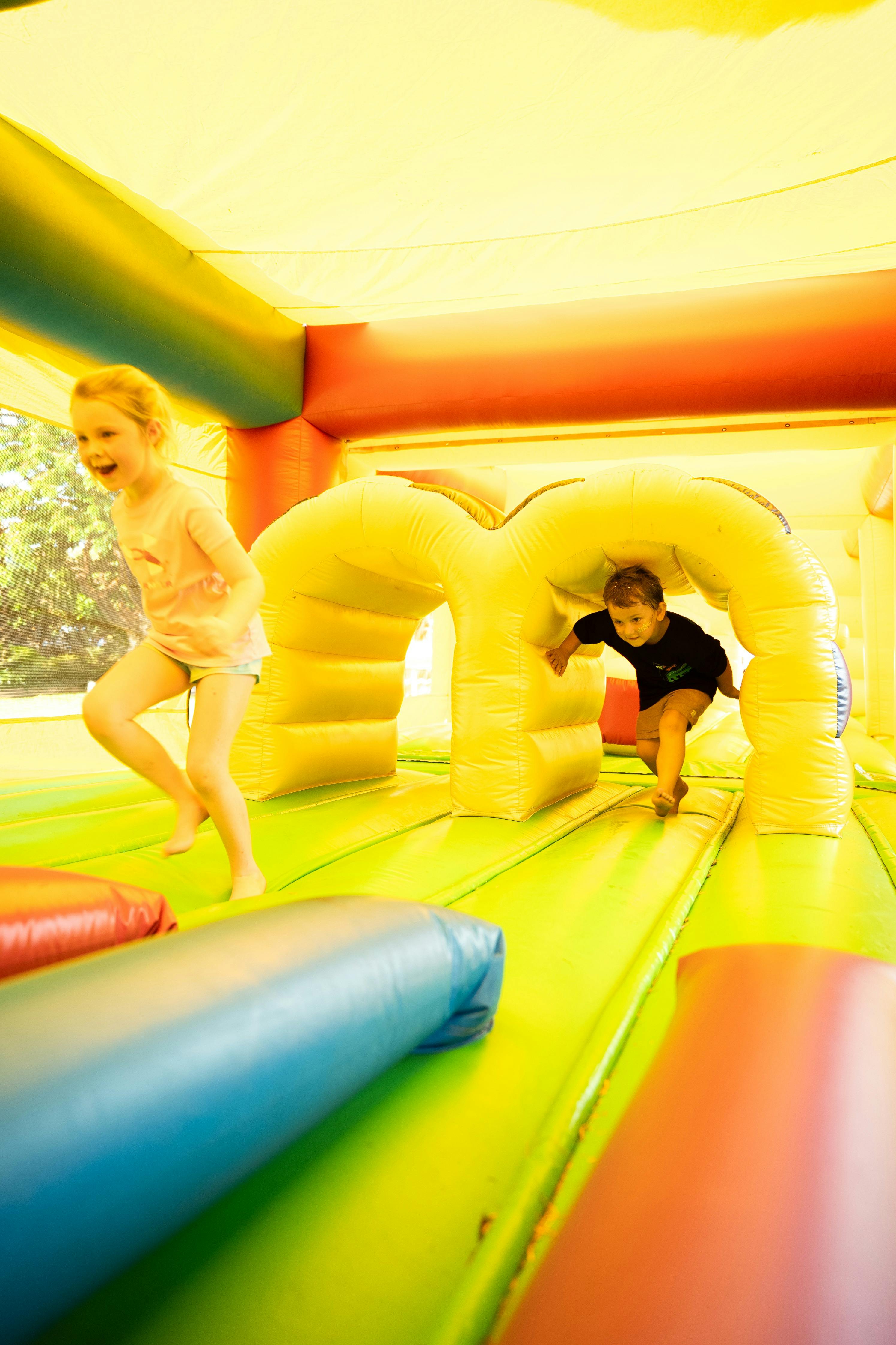 Children running in a yellow jumping castle