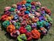 Bright coloured spools of yarn placed on grass