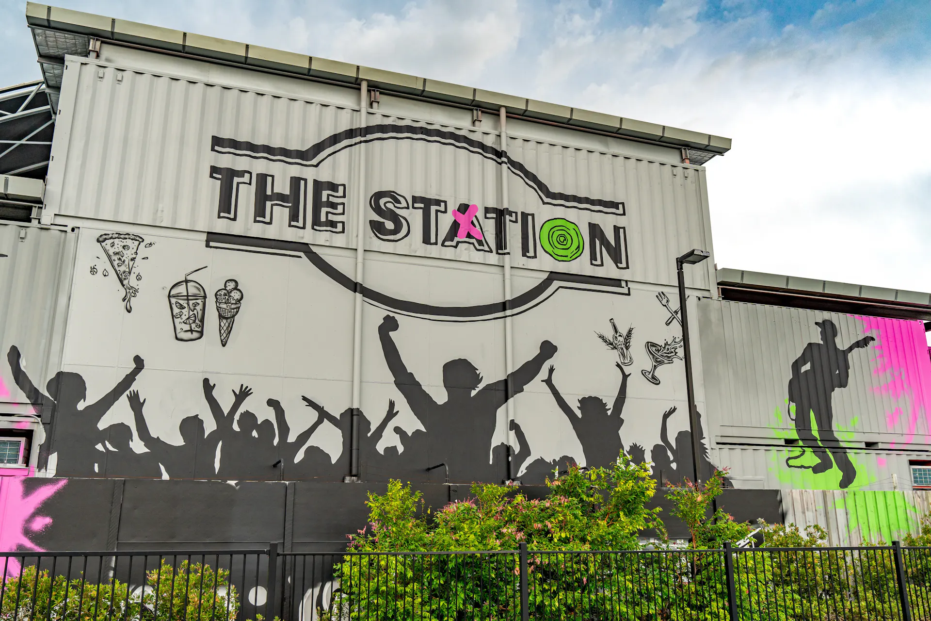 External wall of building showing silhouette of audience with The Station logo