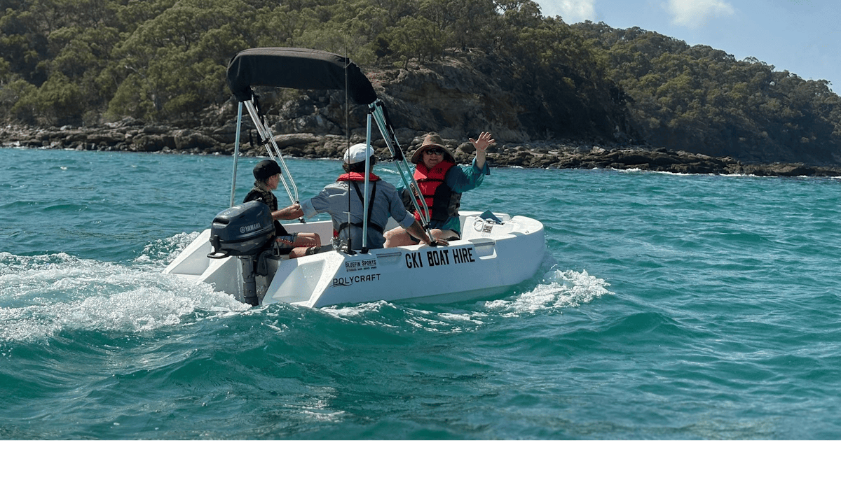 Snorkelling beside hire boats in clear water at Great Keppel Island, QLD.