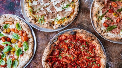 Four types of pizza laid out on a table