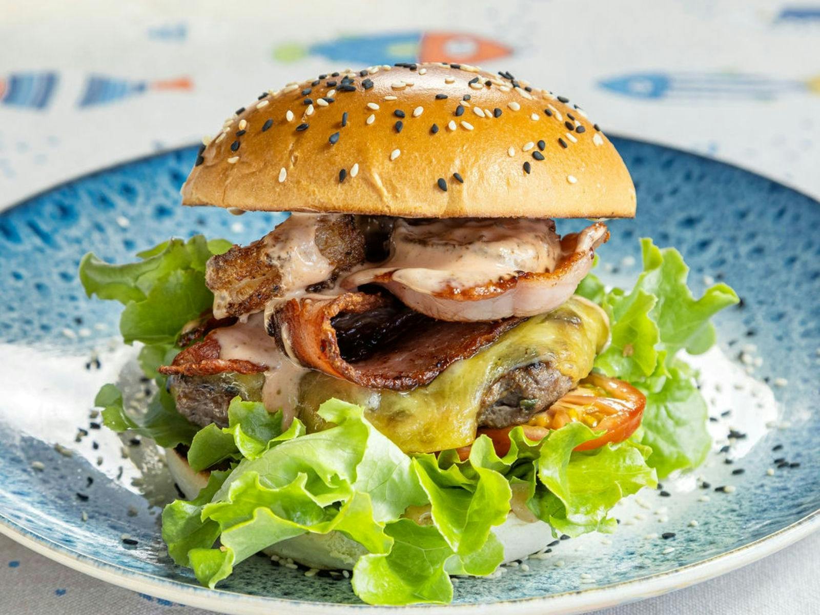 Hamburger on a plate with bacon and lettuce