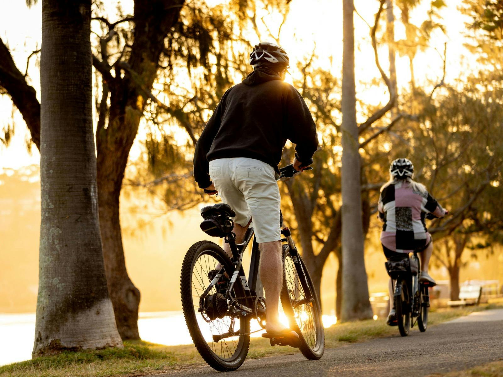Couple riding bikes along a lakefront bike track