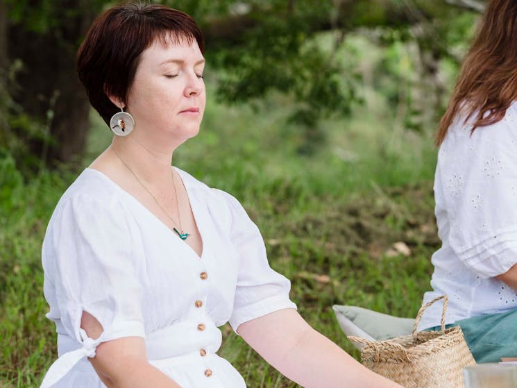 Woman meditating in a white dress